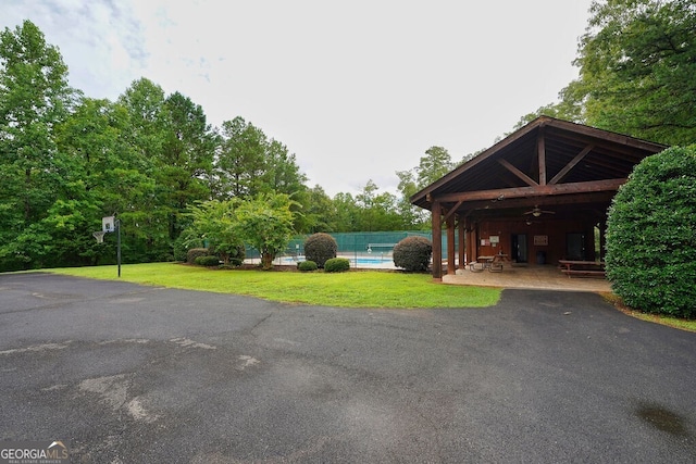 view of parking / parking lot with a yard and ceiling fan