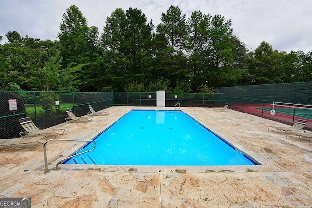 view of pool featuring tennis court