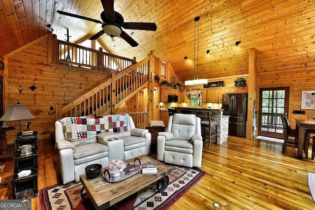 living room with ceiling fan, light hardwood / wood-style floors, wood ceiling, and high vaulted ceiling