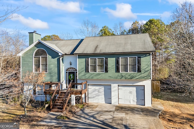 raised ranch featuring a garage and a deck