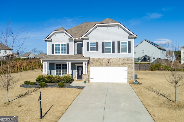 view of front of house with covered porch, a garage, and a front lawn