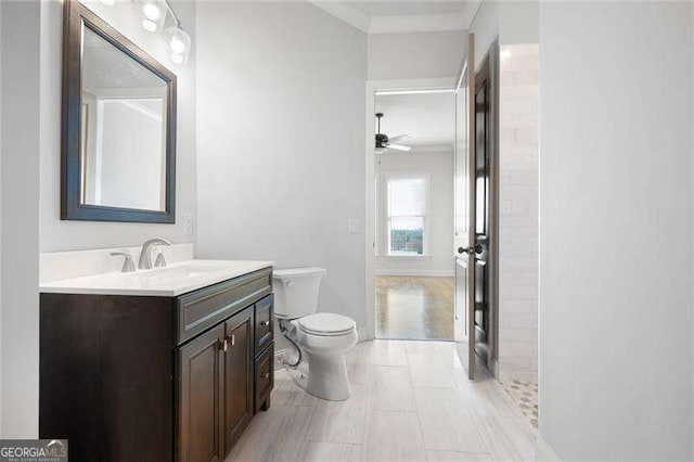 bathroom featuring ceiling fan, vanity, ornamental molding, and toilet