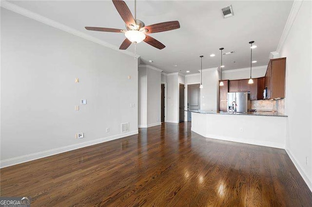 unfurnished living room featuring ceiling fan, crown molding, and dark wood-type flooring