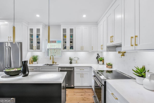 kitchen featuring glass insert cabinets, white cabinetry, appliances with stainless steel finishes, and a sink