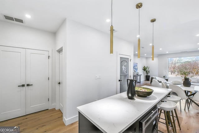 kitchen featuring recessed lighting, visible vents, open floor plan, hanging light fixtures, and light wood-type flooring