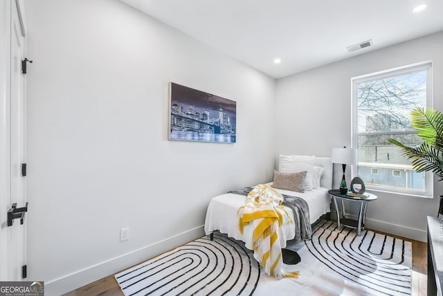 bedroom with baseboards, visible vents, wood finished floors, and recessed lighting