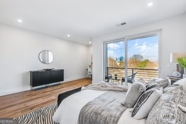 bedroom with recessed lighting, wood finished floors, visible vents, baseboards, and access to exterior