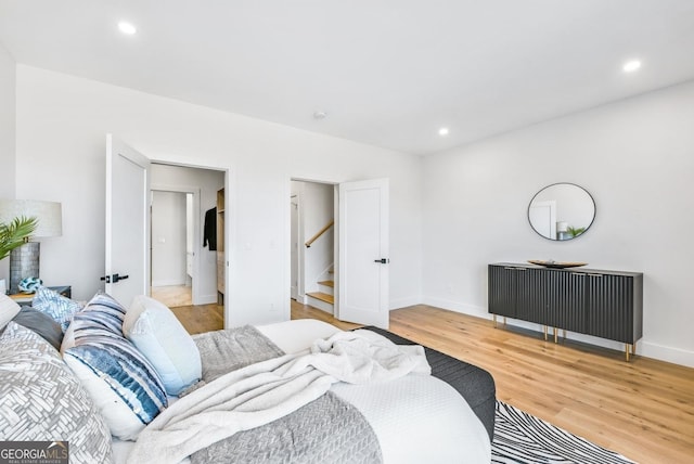 bedroom featuring baseboards, wood finished floors, and recessed lighting