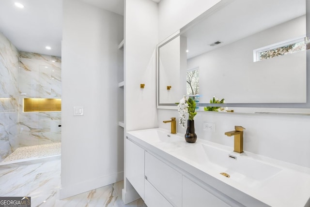 bathroom featuring marble finish floor, a marble finish shower, double vanity, visible vents, and a sink