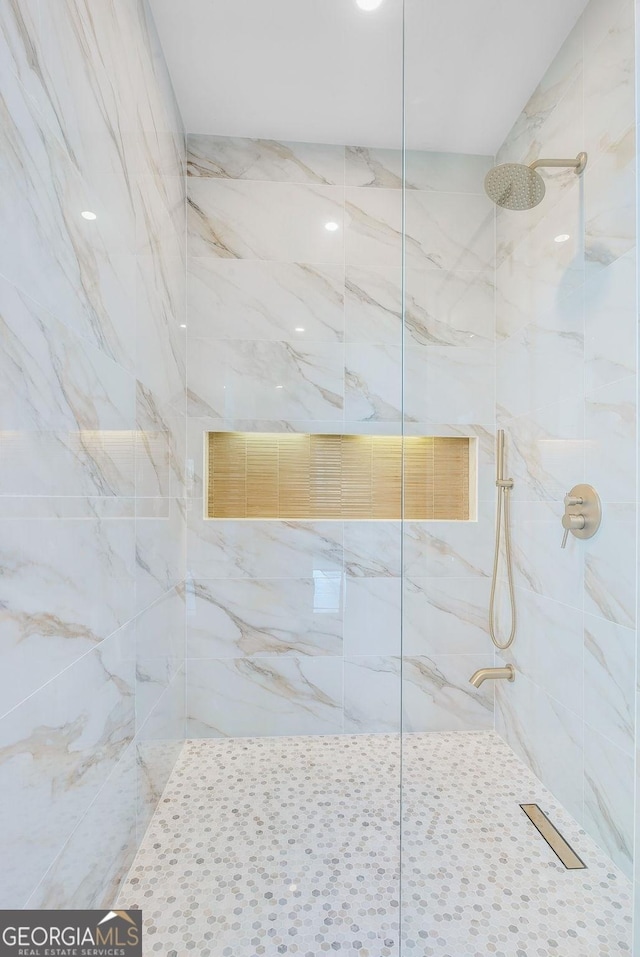 bathroom featuring a marble finish shower