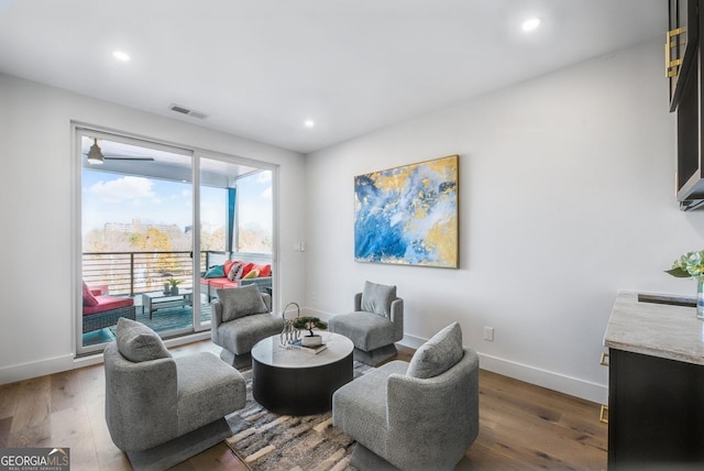 living area with dark wood-style floors, visible vents, baseboards, and recessed lighting