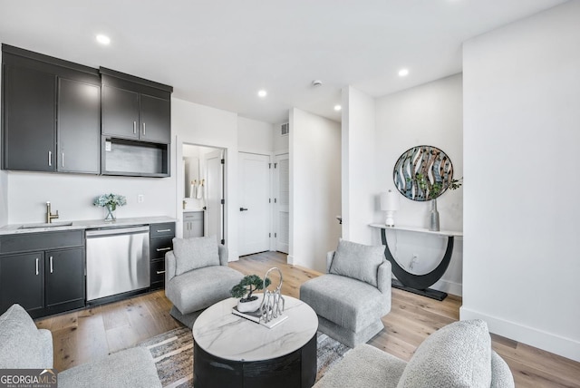 sitting room with light wood-type flooring, visible vents, baseboards, and recessed lighting