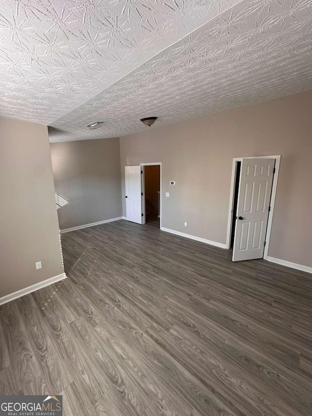 spare room with dark hardwood / wood-style flooring and a textured ceiling