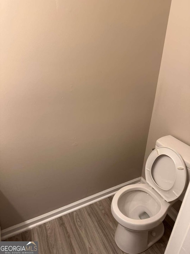 bathroom with hardwood / wood-style flooring and toilet