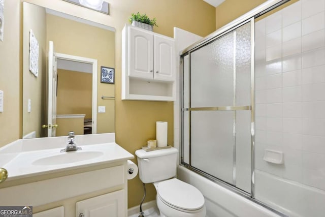 full bathroom with combined bath / shower with glass door, vanity, and toilet