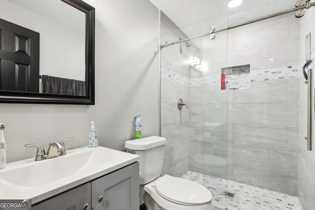 bathroom featuring vanity, toilet, and a shower with door