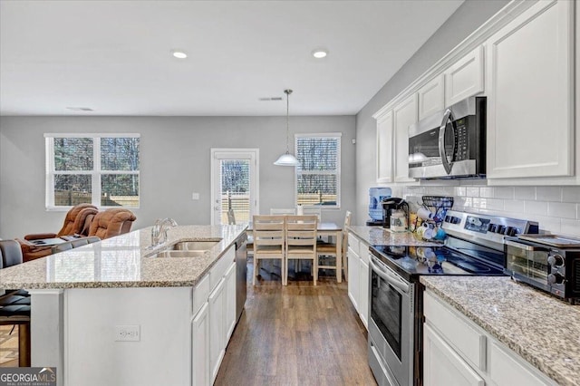 11945 Lovejoy Crossing Way, Hampton, GA 30228 - kitchen with stainless steel appliances, white cabinetry, dark wood finished floors, a breakfast bar, and recessed lighting