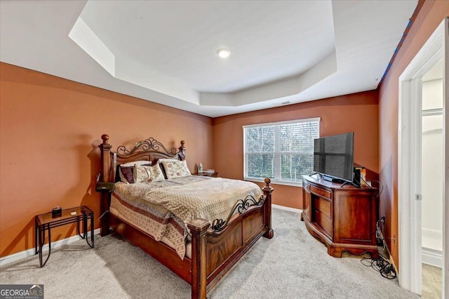 carpeted bedroom with a raised ceiling