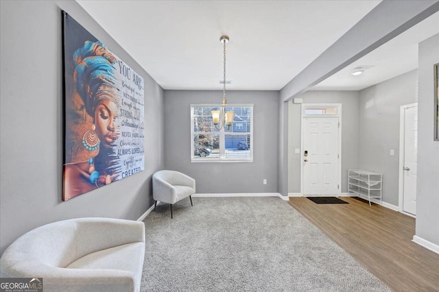 living area featuring hardwood / wood-style flooring, an inviting chandelier, and a healthy amount of sunlight