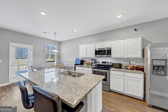 11945 Lovejoy Crossing Way, Hampton, GA 30228 - kitchen with stainless steel appliances, tasteful backsplash, wood finished floors, white cabinets, and recessed lighting