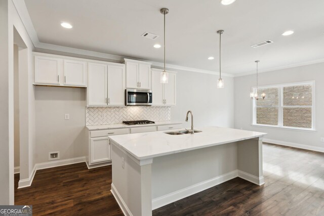 kitchen with pendant lighting, stainless steel appliances, sink, and light stone counters