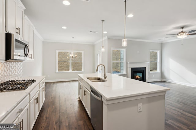 kitchen with pendant lighting, an island with sink, sink, white cabinets, and stainless steel appliances