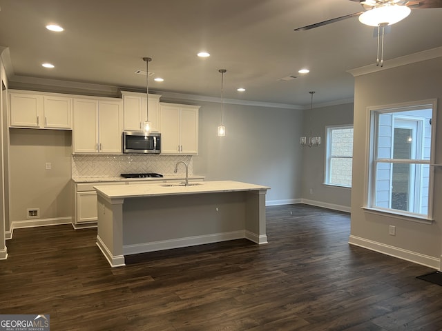 kitchen with white cabinetry, decorative light fixtures, dark hardwood / wood-style flooring, and an island with sink