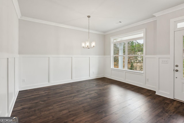 unfurnished dining area featuring crown molding, dark hardwood / wood-style floors, and a chandelier