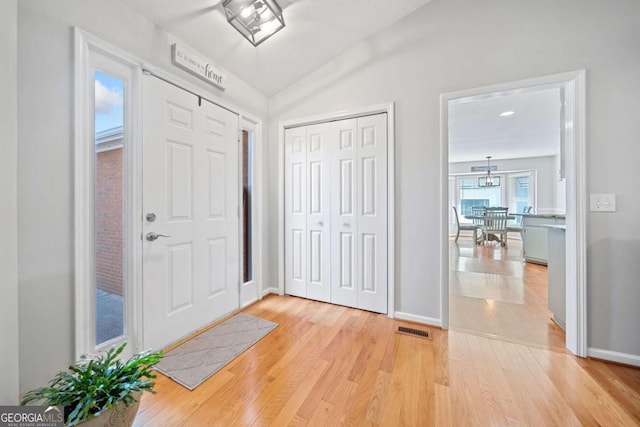 foyer entrance featuring light wood-type flooring and lofted ceiling