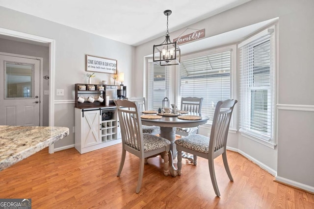 dining room with wood-type flooring and an inviting chandelier