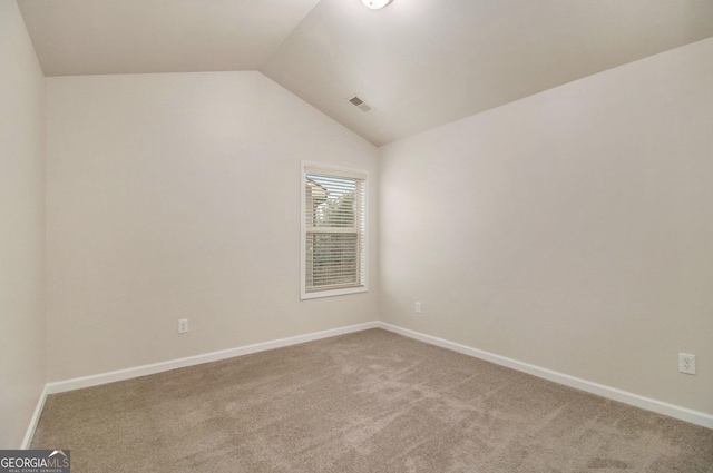 unfurnished room featuring carpet floors and vaulted ceiling