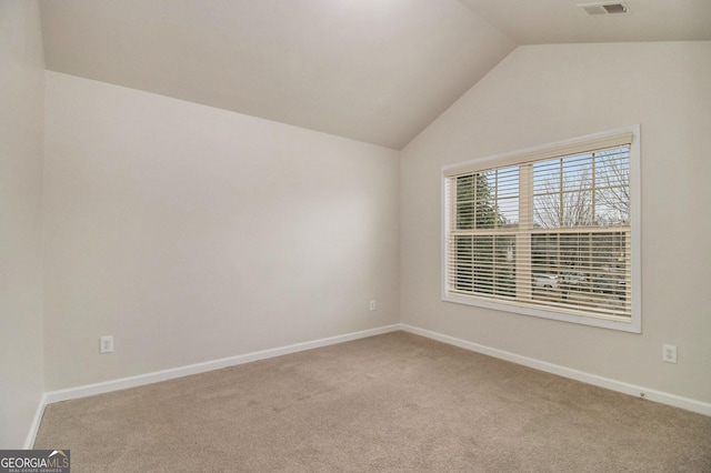 empty room with carpet and vaulted ceiling