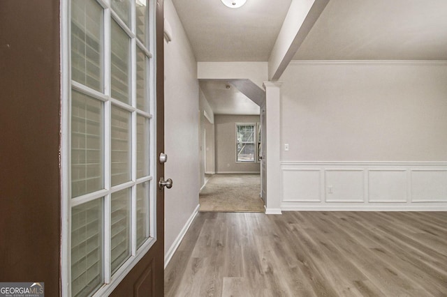 interior space with light hardwood / wood-style flooring and ornamental molding