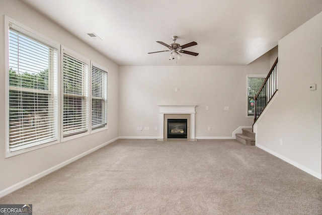 unfurnished living room with ceiling fan and carpet