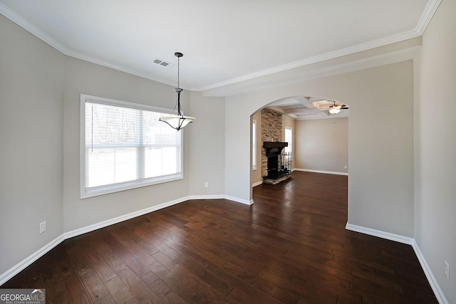 unfurnished dining area featuring a fireplace, dark hardwood / wood-style floors, ceiling fan, crown molding, and coffered ceiling