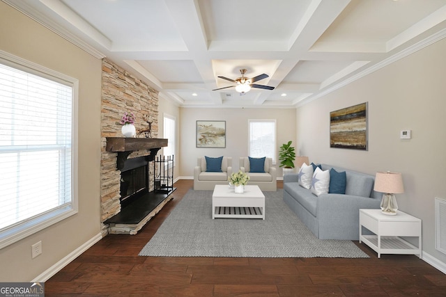 living room featuring a stone fireplace, coffered ceiling, beam ceiling, dark hardwood / wood-style flooring, and ceiling fan