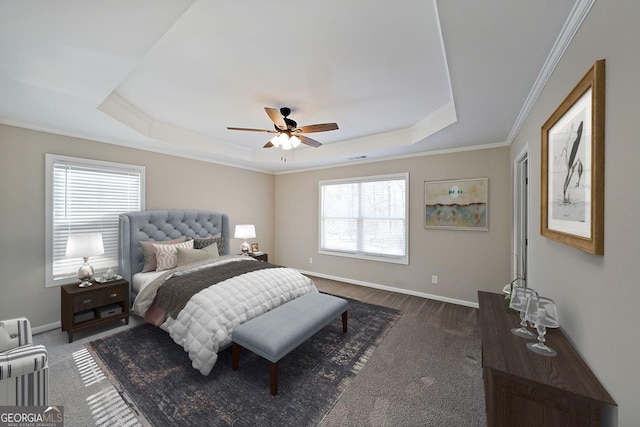 bedroom featuring ceiling fan, ornamental molding, and a tray ceiling