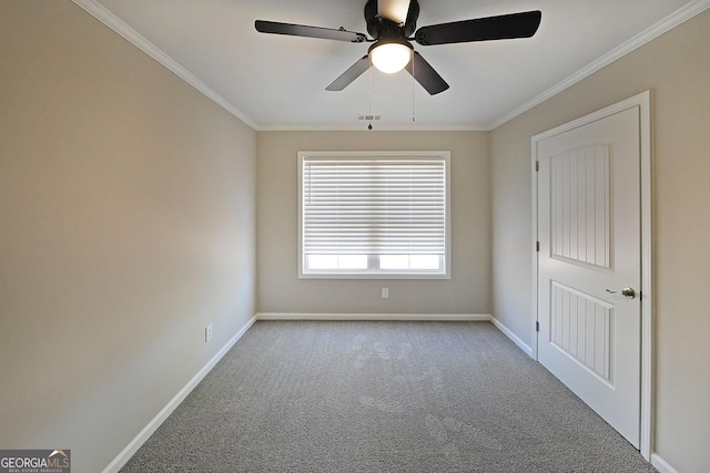 carpeted spare room featuring crown molding and ceiling fan