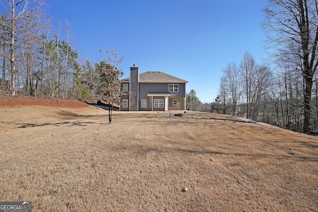 back of house featuring a lawn