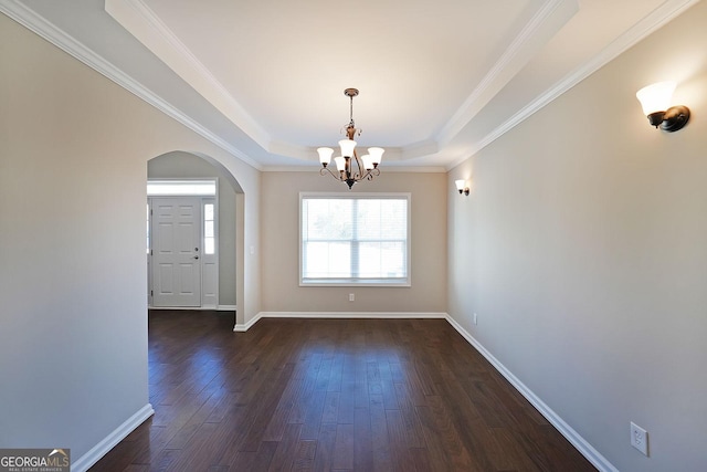 unfurnished dining area featuring crown molding, dark hardwood / wood-style floors, an inviting chandelier, and a tray ceiling