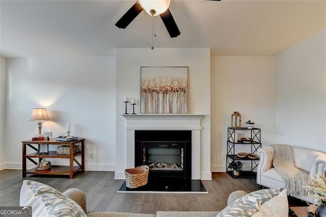 living room featuring ceiling fan and dark wood-type flooring