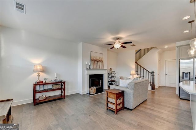 living room with ceiling fan and wood-type flooring