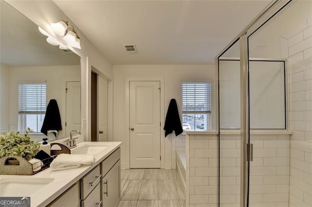 bathroom featuring vanity and independent shower and bath