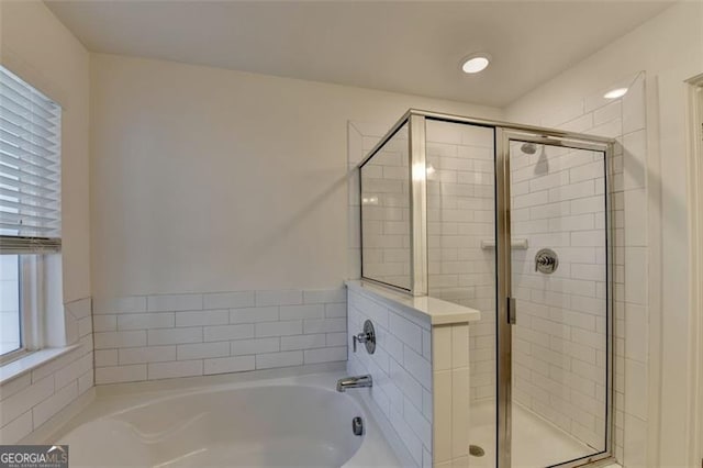 bathroom featuring shower with separate bathtub