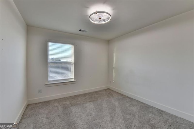 unfurnished room featuring light carpet