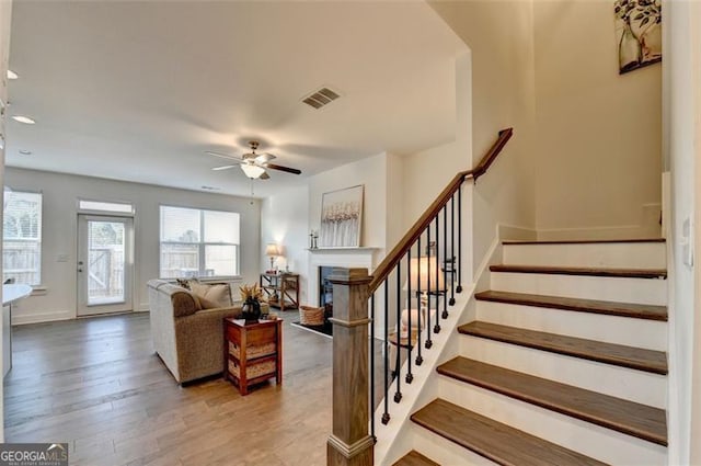 living room featuring wood-type flooring and ceiling fan