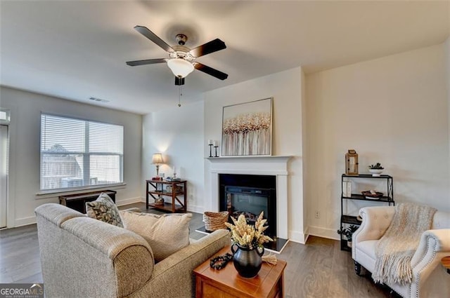 living room featuring ceiling fan and dark wood-type flooring