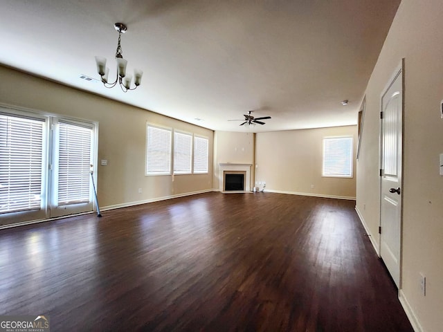 unfurnished living room featuring dark wood-type flooring and ceiling fan with notable chandelier