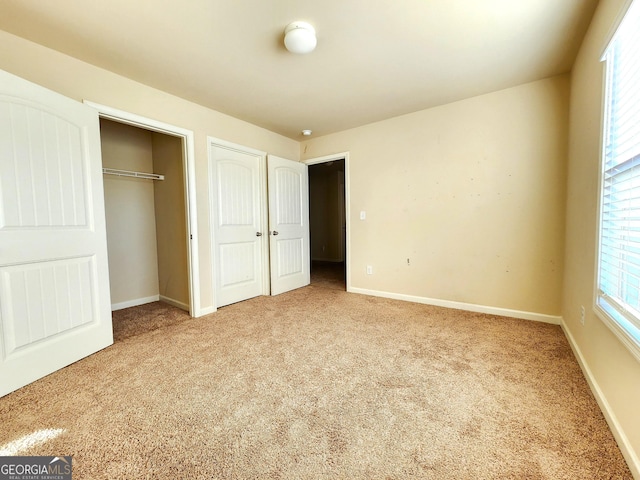 unfurnished bedroom featuring carpet flooring and multiple windows