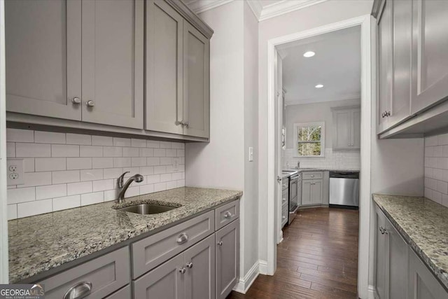 kitchen featuring sink, dark hardwood / wood-style flooring, backsplash, crown molding, and appliances with stainless steel finishes